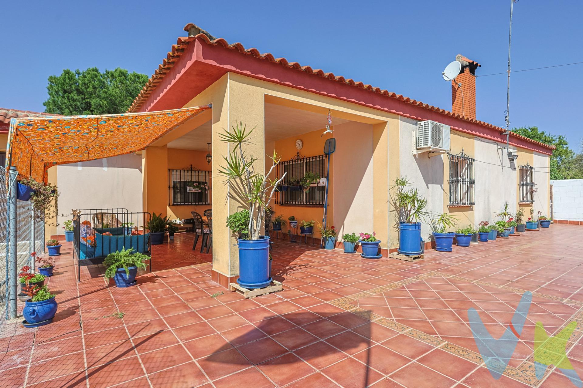 Disponible a la venta este chalet independiente (NO HIPOTECABLE) de 254 m2 de construcción en  1.700m2 de parcela en la Urbanización La Hermandad de Coria del Río, con:. Vivienda aislada en planta baja para entrar a vivir a la que se accede por un poche cubierto de 15 m2 ideal para las noches tórridas de verano.  La vivienda tiene 144 m2 construidos distribuidos en:. - Hall de entrada. - Amplia cocina con isla, amueblada con encimera de granito y equipada con campana extractora, placa vitrocerámica, horno y microondas. Cabe destacar el techo con vigas falsas de madera y artesonado con piezas de cerámica. - Gran salón comedor con vistas a la piscina, con chimenea y split frío - calor. - 4 dormitorios dobles de gran tamaño, todos con tomas TV. - Distribuidor con sala de estar. - Baño con placa ducha con mampara y lavabo encastrado en mueble con espejo a juego. Cabe destacar las buenas calidades de la casa: solería de terrazo, ventanas aluminio con mosquiteras, puertas de paso de madera, fachada con terminación de monocapa, etc. La vivienda tiene luz, agua (de pozos comunitarios), y el saneamiento es por pozo negro. De comunidad se paga 45€/mes agua incluida sin límite de consumo. . Garaje - taller de 95 m2 con capacidad para 3 vehículos, con baño con placa ducha y trastero. El garaje - taller dispone de gran chimenea ideal para las reuniones familiares en invierno. El Garaje dispone de cuadro eléctrico independiente de la vivienda. Cabe la posibilidad de trasformar el garaje - taller en una segunda vivienda. . Gran piscina de 47 m2 con 3  focos de iluminación nocturna, depuradora y ducha. . El jardín delantero dispone de:. - Acceso asfaltado a la vivienda con garaje en superficie con capacidad para 4 vehículos. -Árboles frutales, y arbustos aromáticos:.  * 8 naranjos, un limonero, dos granados, una higuera, tres moreras.  * un olivo, una encina.  * laurel,  romero, yerbabuena y menta. - 3 gallineros: uno de invierno, otro de verano y uno de crianza. Hay 8 gallinas y un gallo. - Jaula para un conejo. - 3 puntos de agua para riego. . La urbanización La Hermandad se encuentra en el término municipal de Coria del Río en el otro margen del río, más cerca de Dos Hermanas y del barrio de Bellavista (Sevilla). Por su cercanía a Bellavista se encuentra próximo al Hospital de Valme, colegios de educación primaria y secundaria, supermercados, etc. También se encuentra muy cerca del Polígono la Isla y muy cerca por tanto del acceso a la S-30 y S-40. . Informamos a nuestros clientes que el precio de venta no incluye lo siguiente: impuestos (el Impuesto de Transmisiones Patrimoniales, I.V.A. o A.J.D., en su caso), otros gastos de la compraventa (gastos de registro de la propiedad, notaría, gestoría). Documento D.I.A. a disposición del consumidor según Decreto 218/2005 Junta de Andalucía Y Ley 12/2023, de 24 de mayo, por el Derecho a la Vivienda. HONORARIOS DE GESTION AL COMPRADOR NO INCLUIDOS EN EL P.V.P. 