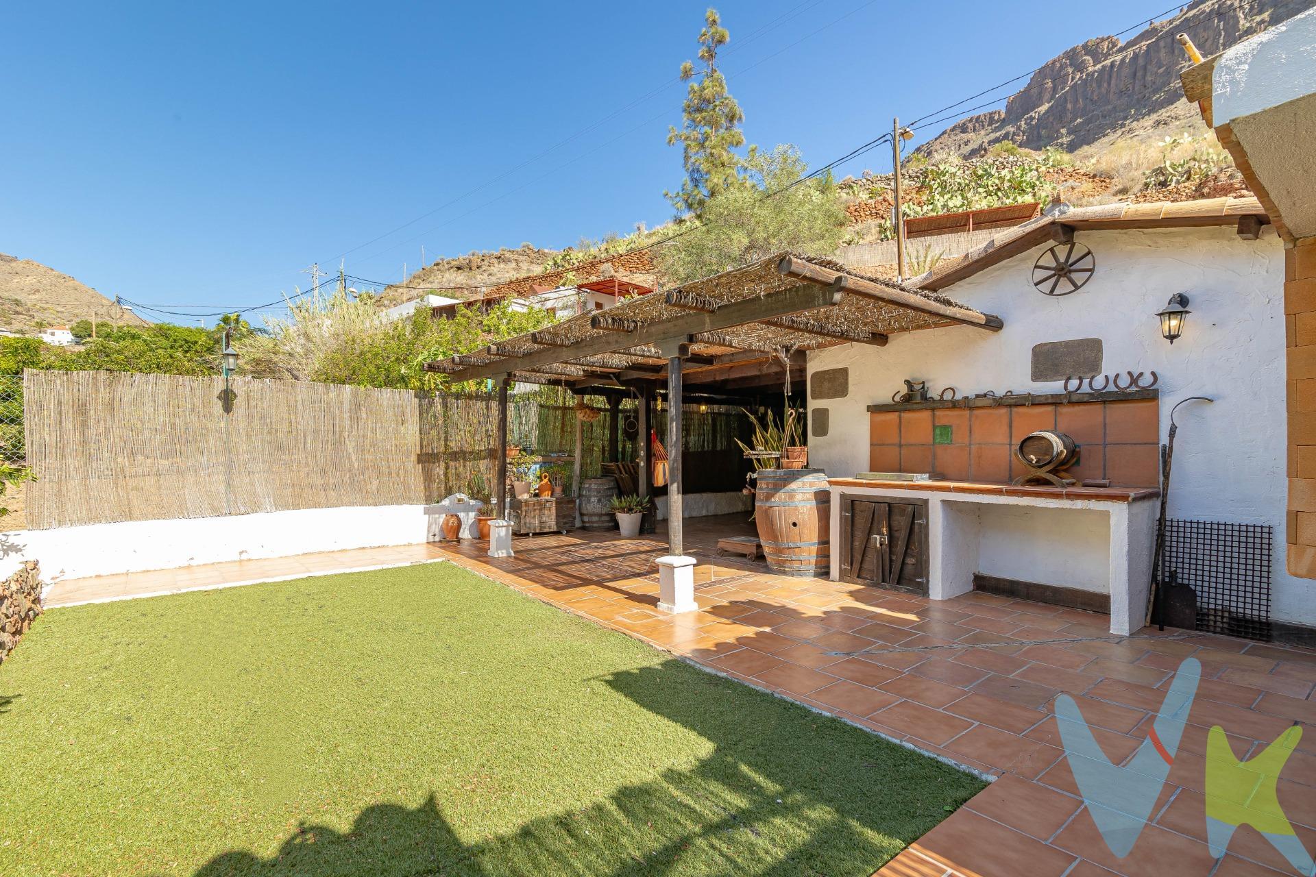 En armonía con la naturaleza: encantadora finca con terreno en Ayagaures:. El sur de Gran Canaria oculta impresionantes paraísos naturales, como el Barranco de Ayagaures. Excursionistas y senderistas aprecian esta zona. La carretera serpentea a lo largo de vegetación típica canaria y casas tradicionales, rodeada por las imponentes montañas, hasta el embalse de Ayagaures. En medio de este impresionante paisaje, bordeado de cactus, palmeras, dragos y pinos canarios, se encuentra esta bonita finca en venta. Situada junto a la carretera, se llega a la parcela vallada (aprox. 727 m2). La finca desprende un encanto muy especial. El porche en la entrada impresiona con materiales naturales por todos lados. Es un lugar donde se sentirá como en casa. Bajo del techo de una pérgola de madera, hay una terraza con rincones diseñados con mucho amor y acogedoras zonas con muebles rústicos, que invitan a desconectarse del mundo. Una bonita zona de barbacoa con parrilla y horno de ladrillo ofrece un lugar maravilloso para pasar tiempo con la familia y los amigos. La finca cumple, lo que promete. También el interior representa el encantador estilo rústico.                                                                                                        . El salón (con aire acondicionado y calefacción) le da la bienvenida con una bonita cocina rústica y una chimenea. Tragaluces en el techo inclinado proporcionan luz natural. Esta zona acogedora invita a tumbarse en el sofá junto a la chimenea, disfrutando de tranquilidad. Hay otra cocina independiente y equipada a su disposición. Un bonito dormitorio doble promete dulces sueños. El cuarto de baño con ducha continúa el diseña rústico. En las habitaciones impresionan decorativas vigas de madera que embellecen los techos inclinados. Las paredes están decoradas con Lajas, una típica piedra natural. La propiedad encanta por su sencillez en combinación con elementos naturales y colores marrones y tierra, que transmitan mucha armonía. Incluyendo la terraza, tiene aproximadamente 107 m2 construidos a su disposición. . Además, en el exterior, pequeños pasillos llevan a la zona plantada. Usted encuentra árboles frutales, plantas exóticas y suculentas. Como nuevo propietario, aquí usted podría cultivar sus propias plantas, árboles, frutas y verduras. ¿No es una idea tentadora?. Ayagaures forma parte del municipio turístico de San Bartolomé de Tirajana. El pintoresco paisaje está rodeado por el impresionante macizo montañoso. En invierno, el barranco se convierte en un paraíso verde. Alrededor encontrará encantadores restaurantes (incluido un restaurante cueva enfrente), enclavados en este impresionante paisaje natural. . En aprox. 20 minutos en coche usted llega al sur turístico, así como al mar y a las playas de Playa del Inglés, Maspalomas y Meloneras. El Palmitos Park y el moderno centro comercial El Tablero también están a unos 20 minutos en coche. El embalse de Ayagaures está a 5 minutos a pie. Este tranquilo oasis puede ofrecer al nuevo propietario un hogar lleno de calidez en armonía con la naturaleza. Aproveche esta oportunidad y póngase en contacto con nosotros. El precio no incluye impuestos y gastos de la compraventa: Impuesto de Transmisiones Patrimoniales (6,5%), honorarios de Notario, Registro de la Propiedad y gestoría. La oferta se sujeta a errores, cambios de precio, omisión y/o retirada del mercado sin aviso previo.