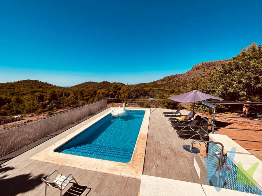 ¿Te gustaría vivir rodeado sólo de la naturaleza de la Sierra Calderona? Tenemos la casa perfecta para desconectar, teletrabajar y respirar la paz que siempre has soñado. Situada en medio de la montaña, subiendo a la Mola de Segart, linde de la Sierra Calderona, comarca Camp de Morvedre, una espectacular parcela de 1.910m2 con casa , te espera para compartir momentos únicos, disfrutando de su jardín, su piscina, o de un paellero de 18m2 los domingos, hay zona para aparcar varios coches e incluso  de la sombra de un algarrobo, momento siesta. ¡Qué más se puede pedir! La casa se encuentra en suelo rústico. Está reformada y actualizada, distribuida en cuatro habitaciones, tres dobles y una sencilla así como un salón comedor con cocina office y salida a una terraza de más de 30m2 con unas vistas panorámicas, de ensueño que no querrás marcharte desde el momento que cruces la puerta. Hay luz, internet y agua de pozo con algibe, con dos acciones de la sociedad de regantes y fosa séptica. La parcela está adaptada para personas con movilidad reducida, iluminación perimetral y la puerta de entrada está motorizada y con videoportero, además de estar iluminada la rampa hasta llegar a la vivienda. La vivienda dispone de alarma, chimenea, calefacción frio calor,  aire acondicionado en salón y habitaciones, así como videoportero a la entrada y ejecutándose la fibra óptica. Tanto los municipios de Puzol, Gilet y Rafelbunyol distan a unos 15 minutos, aproximadamente, en coche y en todos ellos hay supermercado que abre incluso los domingos todo el año. La ciudad de Valencia a unos 35 minutos. ¿Quieres más información? La vida en plena naturaleza te espera, rutas para senderistas a pie o en bicicleta son de las más solicitadas por su encanto , incluso el camino para acceder a la vivienda, de unos cinco minutos, es de piedra, sin asfaltar.¿Te gustaría enterarte en primicia de nuestros inmuebles en alquiler y venta? En VIVEKU.ES los publicamos con unos días de antelación.Contamos con 30 años de experiencia acreditada y nuestro objetivo es garantizarle un servicio de compra humano, ético, de calidad, fácil y seguro. Nuestro equipo lo integran agentes con la titulación AIR (Agente Inmobiliario Registrado) y Agentes Certificadores de la categoría Premium en certificación de inmuebles y debidamente registrados en el Registro de Agentes de Intermediación de la CV (RAICV 0743). Consulte en nuestras reseñas de Google lo que opinan los clientes que ya han trabajado con nosotros.El precio NO incluye: Impuestos, gastos de Notaría, registro y honorarios de inmobiliaria. 