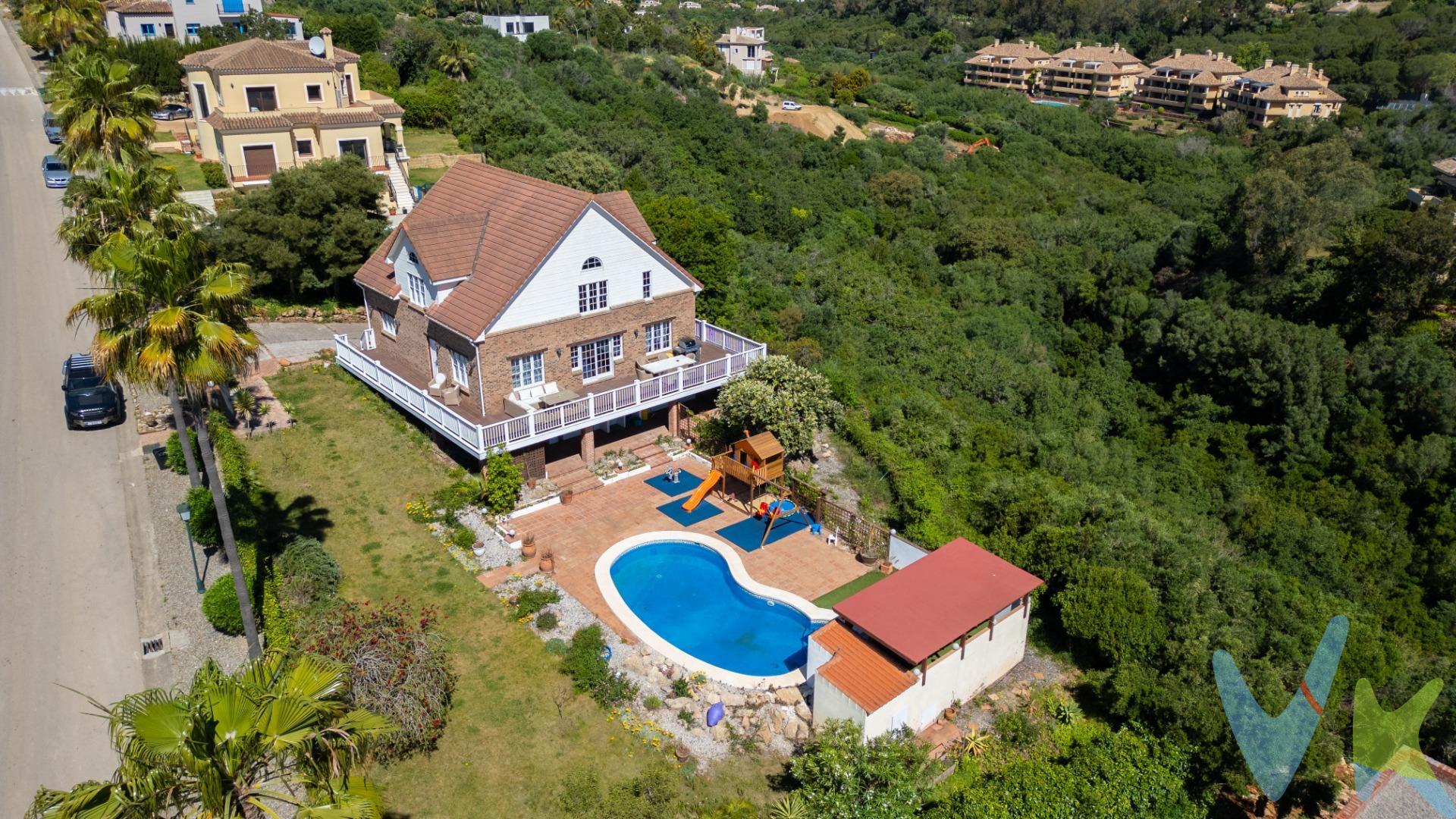 Esta villa independiente y acogedora se encuentra en la exclusiva Zona F de Sotogrande Alto. Con una superficie construida de 557m² y un terreno de 2.127m², esta propiedad cuenta con todas las comodidades para disfrutar de una vida sofisticada. La villa destaca por su diseño y su arquitectura única al más puro estilo de Los Alpes. El interior de madera ofrece unos impresionantes techos y una estructura interior que crea una atmósfera cálida y acogedora. En la planta principal, encontramos dos habitaciones, una de ellas con vestidor, un luminoso salón, una moderna cocina y un comedor estilo "open plan", perfecto para recibir a familiares y amigos. Esta planta se abre a una terraza-mirador donde relajarse con las estupendas vistas panorámicas y al mar. La planta alta alberga la suite principal, que cuenta con un baño privado y una zona de estudio, ideal para trabajar desde casa. En la planta inferior de la villa encontramos una habitación de invitados, una zona de lavandería, una cocina adicional y una habitación que puede ser utilizada como gimnasio o sala de juegos. También cuenta con un garaje privado y cerrado con capacidad para un vehículo, pudiendo aparcar más vehículos en el exterior de la vivienda de manera privada también. El exterior de la propiedad es igualmente impresionante. La villa cuenta con una piscina privada a los pies de un porche con sofá-columpio, ideal para disfrutar del clima mediterráneo. Junto a la piscina hay un parque infantil con suelo acolchado, perfecto para que los más pequeños se diviertan con total seguridad. Desde la villa se pueden disfrutar de increíbles vistas panorámicas al mar y a Sotogrande. Además, su ubicación privilegiada la sitúa cerca de campos de golf de renombre como Valderrama, Almenara o San Roque Club Golf y del Colegio Internacional, lo que la convierte en una opción ideal para familias. La seguridad es una prioridad en esta urbanización, con un servicio de vigilancia las 24 horas del día. Esta villa ofrece lujo, comodidad y tranquilidad en una ubicación privilegiada. No dude en contactarnos para más información y reservar una visita.