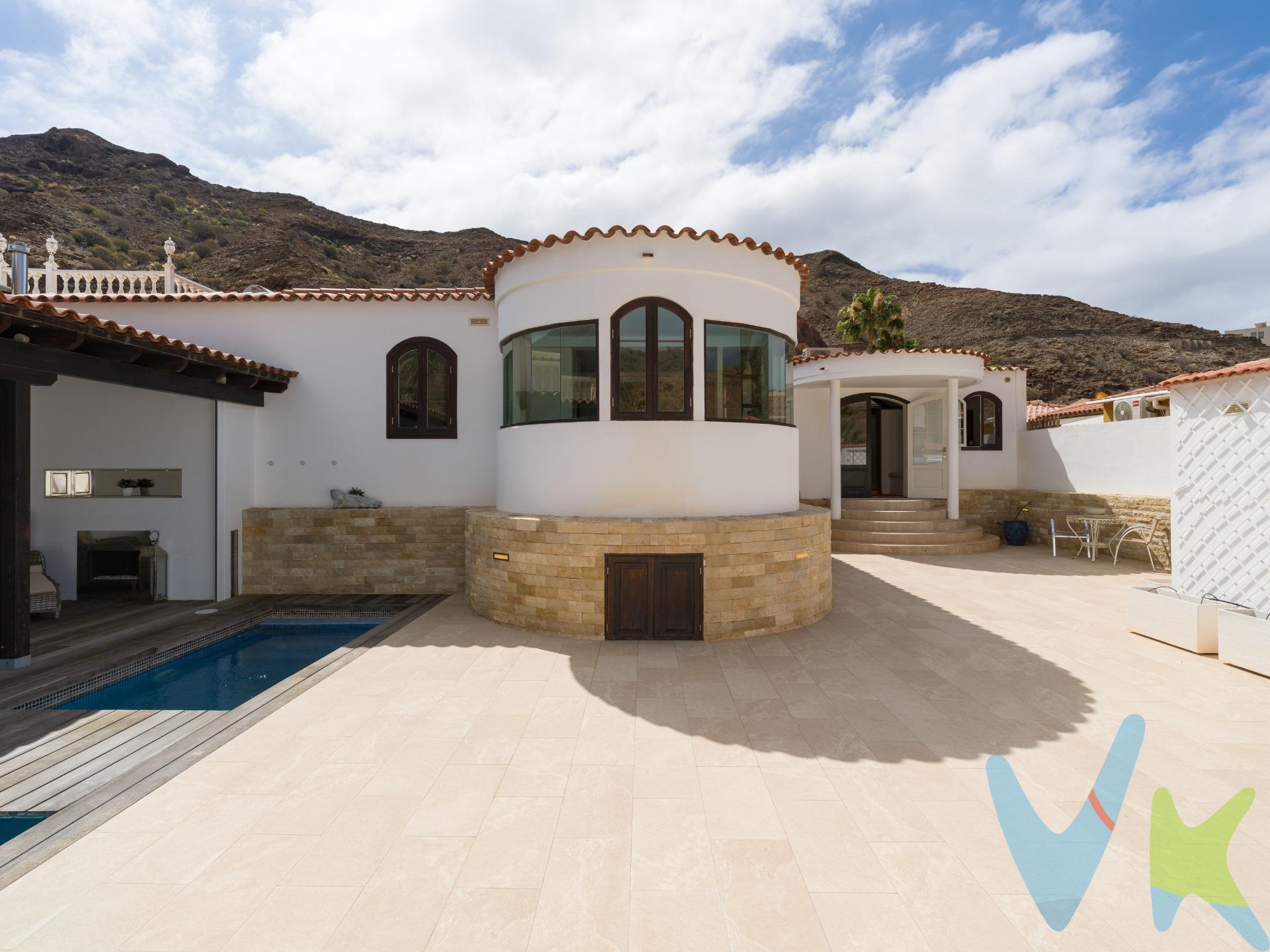 Ubicado en una tranquila y exclusiva zona residencial de Tauro, este elegante chalet independiente ofrece un elevado nivel de privacidad a pocos minutos de Anfi Tauro Golf y la Playa de Amadores. Una ubicación ideal para quienes buscan disfrutar de la tranquilidad, el golf y el excepcional clima del sur de Gran Canaria durante todo el año. La propiedad destaca por su singular arquitectura, la amplitud de sus espacios y una extraordinaria luminosidad presente en todas las estancias. Un impresionante salón, presidido por un espectacular lucernario y una elegante estructura de madera vista, constituye el auténtico corazón de la vivienda, conectando de forma natural con un amplio comedor y creando una atmósfera acogedora y llena de personalidad. La cocina, completamente equipada, incorpora un exclusivo mirador semicircular acristalado que ofrece agradables vistas, convirtiéndose en uno de los espacios más especiales y diferenciadores de la propiedad. La zona de descanso dispone de tres dormitorios, incluyendo una espectacular suite principal con vestidor y bañera de hidromasaje, así como un segundo dormitorio con baño privado y despacho que podría convertirse también en vestidor. El tercer dormitorio ubicado en la planta semisótano, disfruta de luz natural, y una sensación de independencia, resultando ideal como dormitorio de invitados o despacho privado. En el exterior, la propiedad ofrece una amplia terraza con ducha exterior, piscina climatizada, zona de comedor cubierta, cocina exterior y espacios de relax diseñados para disfrutar del excepcional clima de Mogán durante todo el año. La privacidad de la parcela y la tranquilidad del entorno convierten esta vivienda en un refugio exclusivo donde disfrutar del máximo confort. Completan la propiedad un garaje privado cerrado, lavadero independiente equipado, aire acondicionado y excelentes calidades constructivas, incluyendo elegantes suelos de madera. Una propiedad única para quienes buscan una residencia exclusiva junto al golf, cerca del mar y rodeada de privacidad. Precio de Venta al Público (PVP) – No incluye gastos. Impuestos y demás gastos legalmente correspondan al comprador. Inmueble sujeto a ITP del 6,5% con carácter general; existen excepciones según normativa aplicable. Base imponible el mayor valor entre: 1) precio de venta: 2) tasación; 3) valor referencia catastral. Gastos Notaria y Registro entre 0,3% - 0,8% aprox. según aranceles. Financiación: gastos de hipoteca, tasación y gastos bancarios a cargo del comprador y según su necesidad y elección. Honorarios inmobiliaria a cargo del vendedor. Operación y condiciones de compraventa sujeta a aceptación expresa del vendedor. Para acceder a información y documentación legalmente exigible por el consumidor puede contactarnos. Anuncio sujeto a errores, cambios de precio, omisión y/o retirada del mercado sin aviso previo