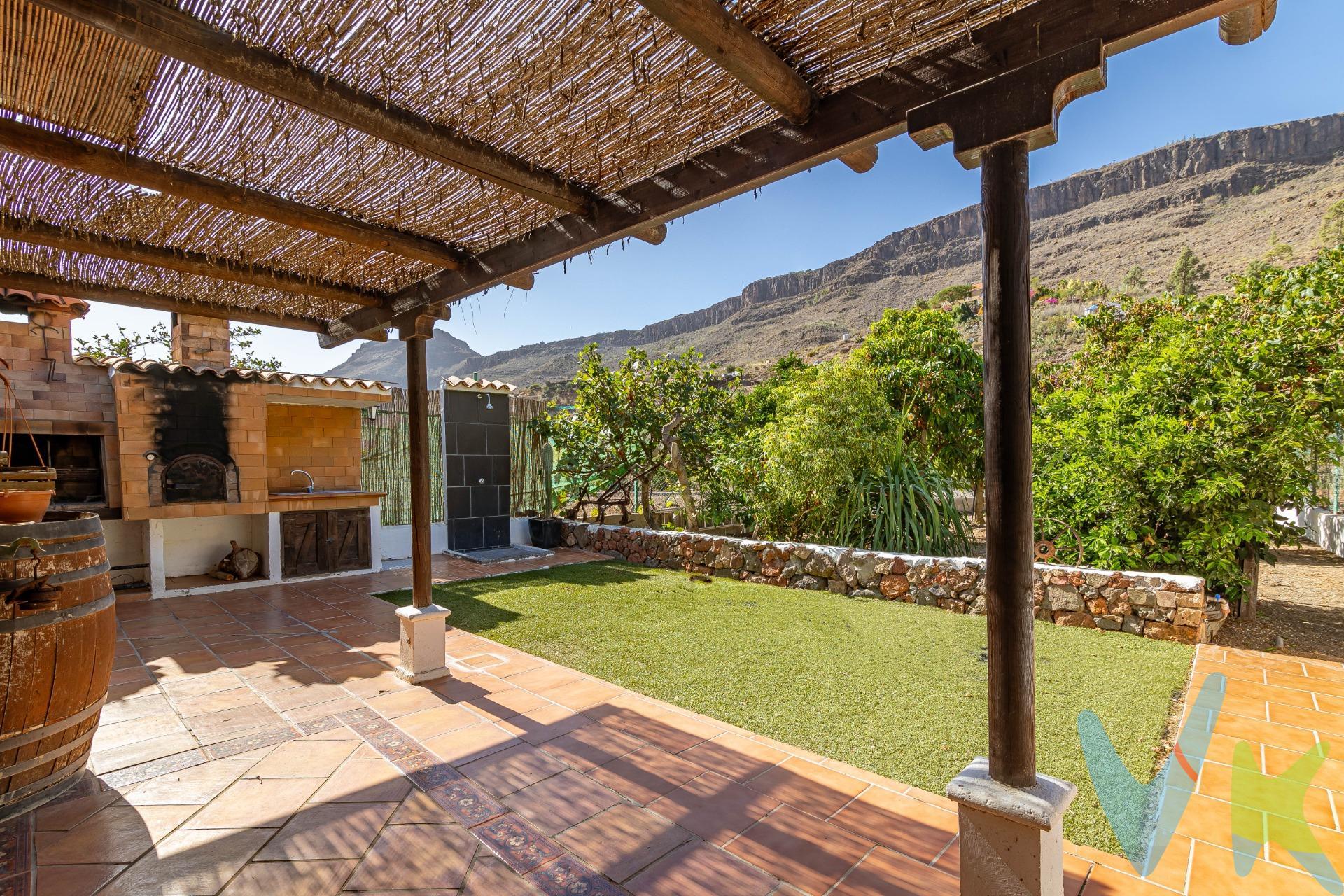 En armonía con la naturaleza: encantadora finca con terreno en Ayagaures:. El sur de Gran Canaria oculta impresionantes paraísos naturales, como el Barranco de Ayagaures. Excursionistas y senderistas aprecian esta zona. La carretera serpentea a lo largo de vegetación típica canaria y casas tradicionales, rodeada por las imponentes montañas, hasta el embalse de Ayagaures. En medio de este impresionante paisaje, bordeado de cactus, palmeras, dragos y pinos canarios, se encuentra esta bonita finca en venta. Situada junto a la carretera, se llega a la parcela vallada (aprox. 727 m2). La finca desprende un encanto muy especial. El porche en la entrada impresiona con materiales naturales por todos lados. Es un lugar donde se sentirá como en casa. Bajo del techo de una pérgola de madera, hay una terraza con rincones diseñados con mucho amor y acogedoras zonas con muebles rústicos, que invitan a desconectarse del mundo. Una bonita zona de barbacoa con parrilla y horno de ladrillo ofrece un lugar maravilloso para pasar tiempo con la familia y los amigos. La finca cumple, lo que promete. También el interior representa el encantador estilo rústico.                                                                                                        . El salón (con aire acondicionado y calefacción) le da la bienvenida con una bonita cocina rústica y una chimenea. Tragaluces en el techo inclinado proporcionan luz natural. Esta zona acogedora invita a tumbarse en el sofá junto a la chimenea, disfrutando de tranquilidad. Hay otra cocina independiente y equipada a su disposición. Un bonito dormitorio doble promete dulces sueños. El cuarto de baño con ducha continúa el diseña rústico. En las habitaciones impresionan decorativas vigas de madera que embellecen los techos inclinados. Las paredes están decoradas con Lajas, una típica piedra natural. La propiedad encanta por su sencillez en combinación con elementos naturales y colores marrones y tierra, que transmitan mucha armonía. Incluyendo la terraza, tiene aproximadamente 107 m2 construidos a su disposición. . Además, en el exterior, pequeños pasillos llevan a la zona plantada. Usted encuentra árboles frutales, plantas exóticas y suculentas. Como nuevo propietario, aquí usted podría cultivar sus propias plantas, árboles, frutas y verduras. ¿No es una idea tentadora?. Ayagaures forma parte del municipio turístico de San Bartolomé de Tirajana. El pintoresco paisaje está rodeado por el impresionante macizo montañoso. En invierno, el barranco se convierte en un paraíso verde. Alrededor encontrará encantadores restaurantes (incluido un restaurante cueva enfrente), enclavados en este impresionante paisaje natural. . En aprox. 20 minutos en coche usted llega al sur turístico, así como al mar y a las playas de Playa del Inglés, Maspalomas y Meloneras. El Palmitos Park y el moderno centro comercial El Tablero también están a unos 20 minutos en coche. El embalse de Ayagaures está a 5 minutos a pie. Este tranquilo oasis puede ofrecer al nuevo propietario un hogar lleno de calidez en armonía con la naturaleza. Aproveche esta oportunidad y póngase en contacto con nosotros. El precio no incluye impuestos y gastos de la compraventa: Impuesto de Transmisiones Patrimoniales (6,5%), honorarios de Notario, Registro de la Propiedad y gestoría. La oferta se sujeta a errores, cambios de precio, omisión y/o retirada del mercado sin aviso previo.