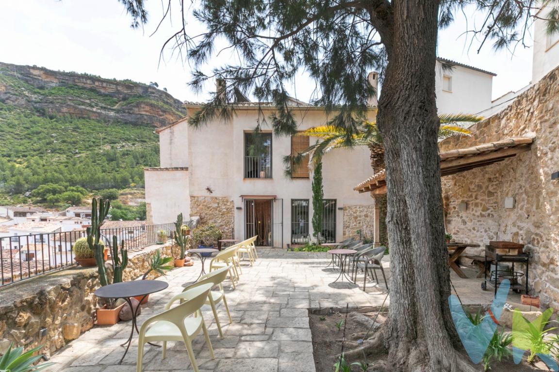 Oportunidad única para inversores: esta espectacular casa rural de 550 m² construidos, ubicada en lo más alto del encantador municipio de Chulilla (Valencia), ofrece la posibilidad de poner en marcha un negocio turístico con rentabilidad inmediata. Situada en un enclave natural privilegiado y con menos de 1.000 habitantes, destaca por sus impresionantes vistas al cañón rocoso y por integrar parte de la antigua muralla árabe en su estructura.Rehabilitada con esmero entre 2005 y 2008 con materiales de alta gama y un estilo rústico auténtico, la propiedad está completamente equipada para operar desde el primer día, sin necesidad de inversión adicional. Cuenta con nueve habitaciones dobles, todas con baño en suite y algunas con balcón privado, además de amplios espacios comunes: salón con chimenea, comedor, cocina equipada, hall de entrada y despacho habilitado como recepción.En la planta inferior, ideal para ofrecer servicios premium, se encuentra una zona de spa con hammam y chorros, dos habitaciones adicionales, lavadero, garaje cubierto y sala de máquinas. Toda la propiedad dispone de ascensor, calefacción central, aire acondicionado por splits, ventanas climalit, sistema antincendios, placas solares para agua caliente sanitaria y jardín privado de 102 m² con vistas inmejorables.Este inmueble, que ha funcionado recientemente como casa rural, está en condiciones óptimas para reabrir de inmediato, convirtiéndose en una inversión segura y rentable desde el primer día. Además, su jardín ofrece potencial para habilitar un restaurante, bar o añadir una piscina, ampliando aún más las vías de ingreso.Una propiedad única, lista para generar beneficios desde el momento en que se adquiere. Contáctenos y descubra una oportunidad que combina encanto, historia y rentabilidad en un solo lugar.